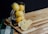 A close-up of a jar filled with vibrant, fermented lemons on a wooden table.