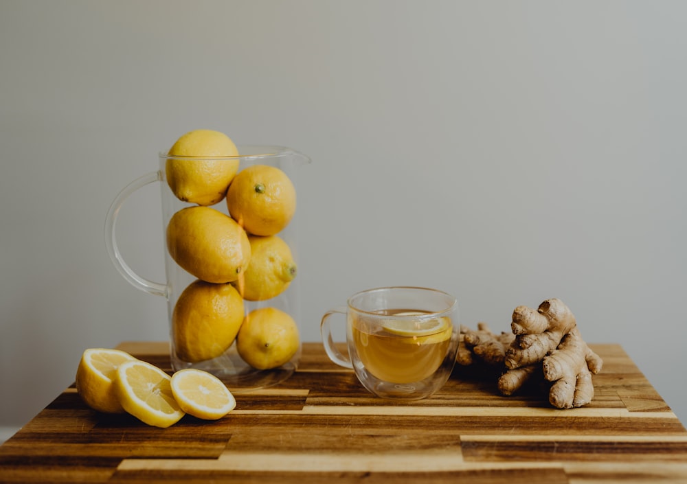 a wooden table topped with lemons and ginger