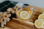 a cup of tea with lemon and ginger on a cutting board