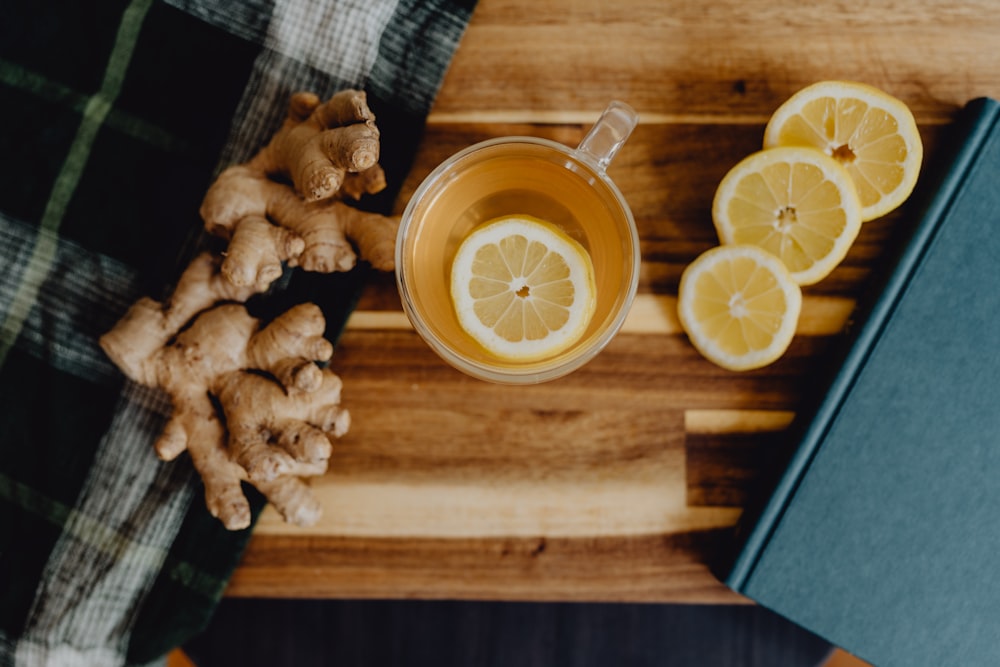 a cup of tea with lemon and ginger on a wooden table