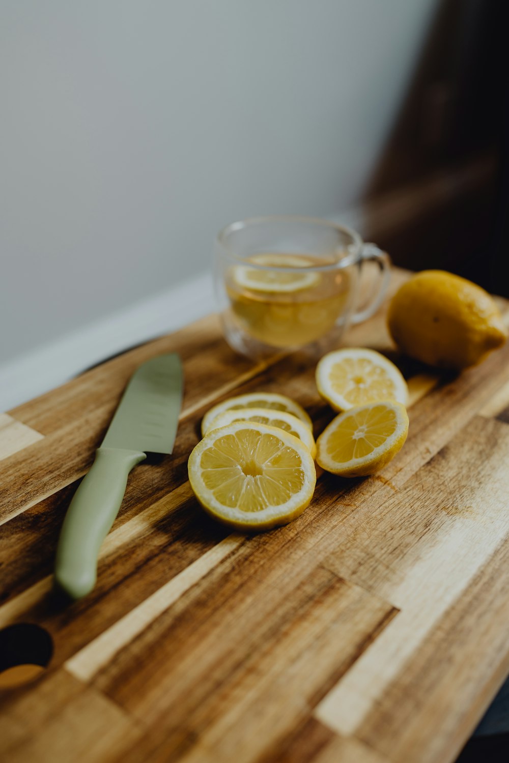 a cutting board topped with sliced lemons and a knife