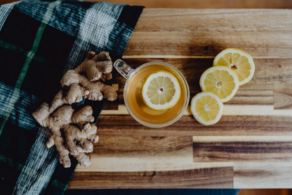 a cup of tea with lemon and ginger on a wooden table