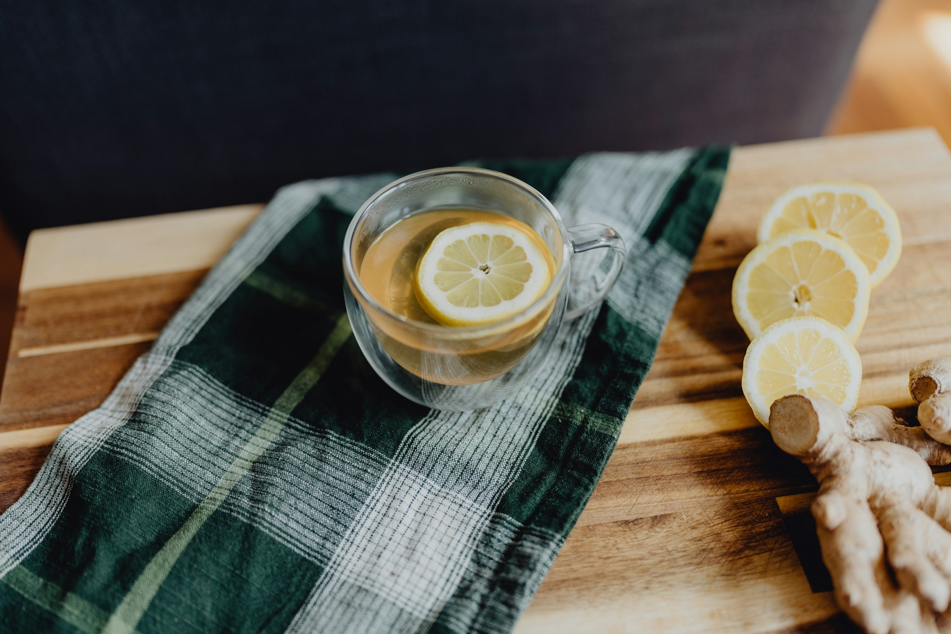 A vibrant image showcasing a steaming cup of ginger tea with a slice of lemon on the side.
