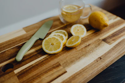a cutting board topped with sliced lemons and a knife