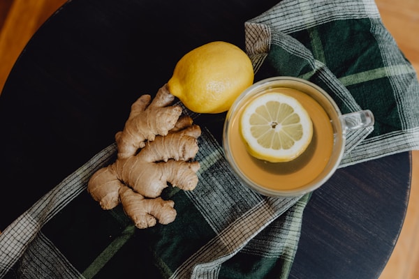 A cup of tea with lemon and ginger on a table