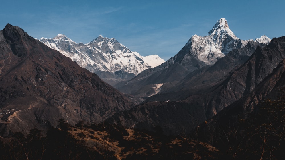 a mountain range with snow capped mountains in the background