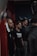 Several men stand in a gym environment, appearing focused and attentive. One of the men is wearing a black t-shirt with the word 'CrossFit' on it. The atmosphere suggests a training or group workout setting.