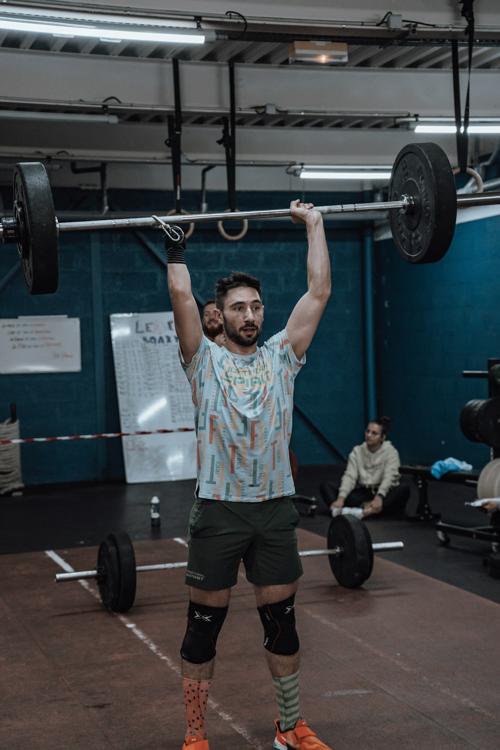 a man is lifting a barbell in a gym