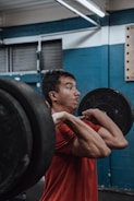 A focused man lifting heavy weights in a gritty gym setting.