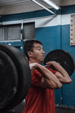 A focused man lifting heavy weights in a gritty gym setting.