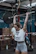 Close-up of a woman lifting weights in a modern gym, radiating strength.
