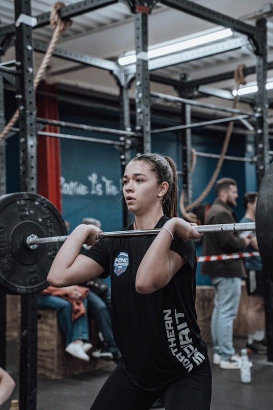 a woman lifting a barbell in a crossfit gym