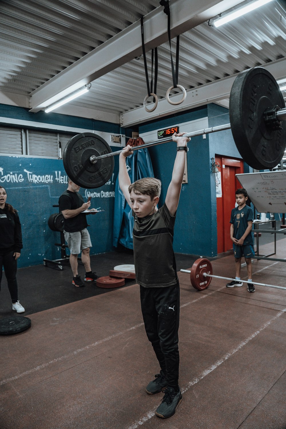 a young man lifting a barbell in a gym