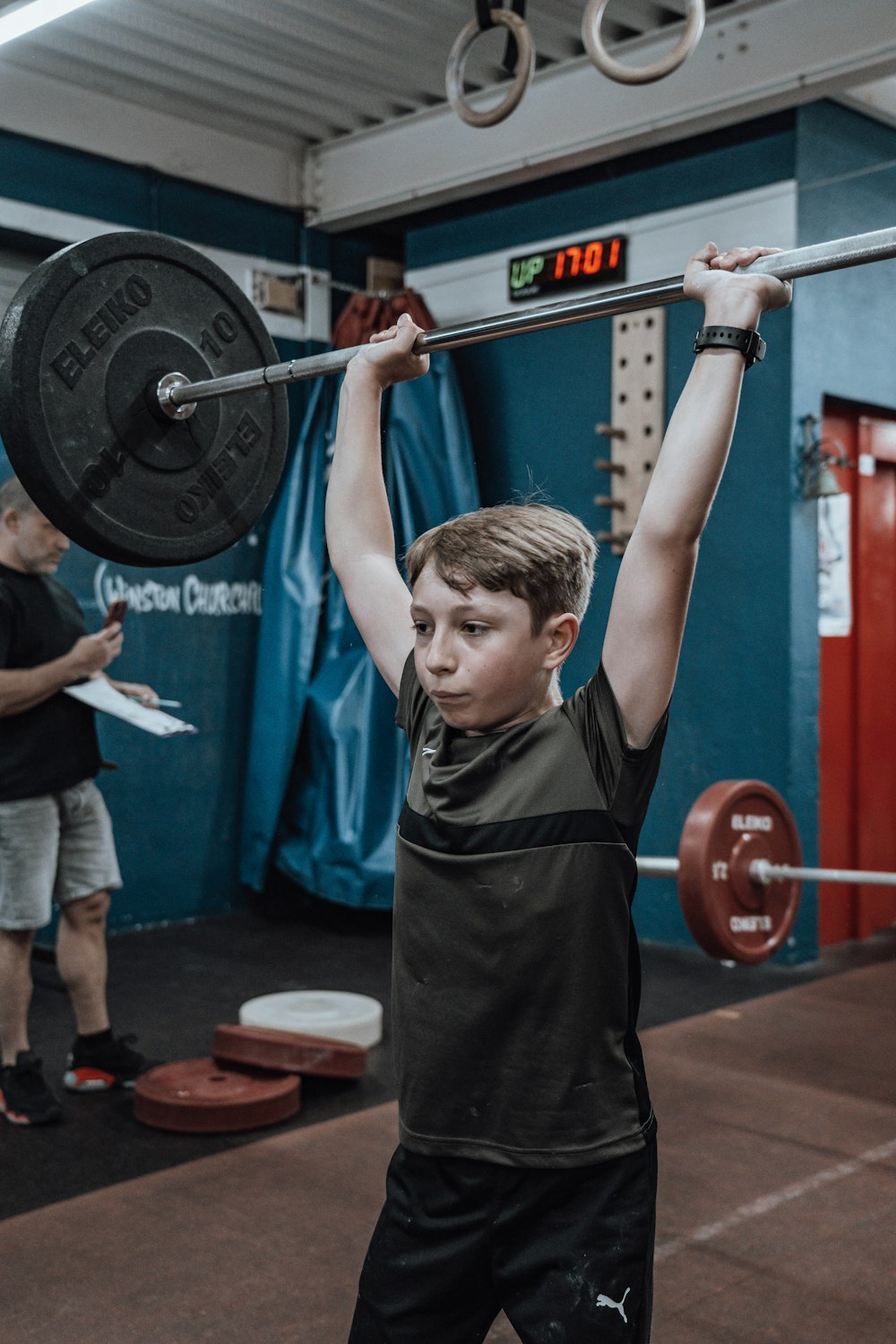 Un niño levantando una barra en un gimnasio