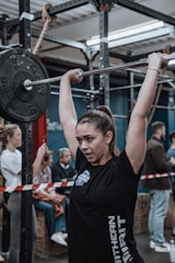 A woman lifting weights with focus in a modern gym setting