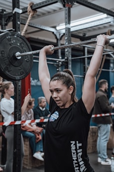 A woman lifting weights with focus in a modern gym setting