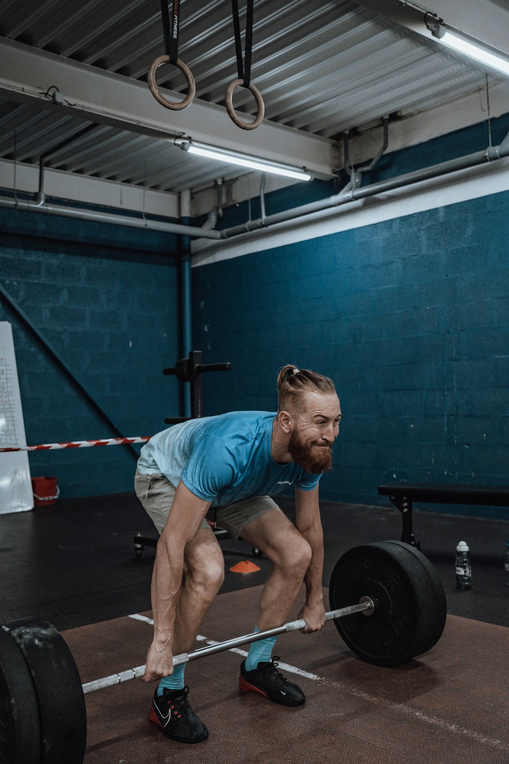 a man with a beard squatting on a barbell