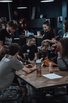 A small group gathered around a table with energy-saving devices and informational posters.