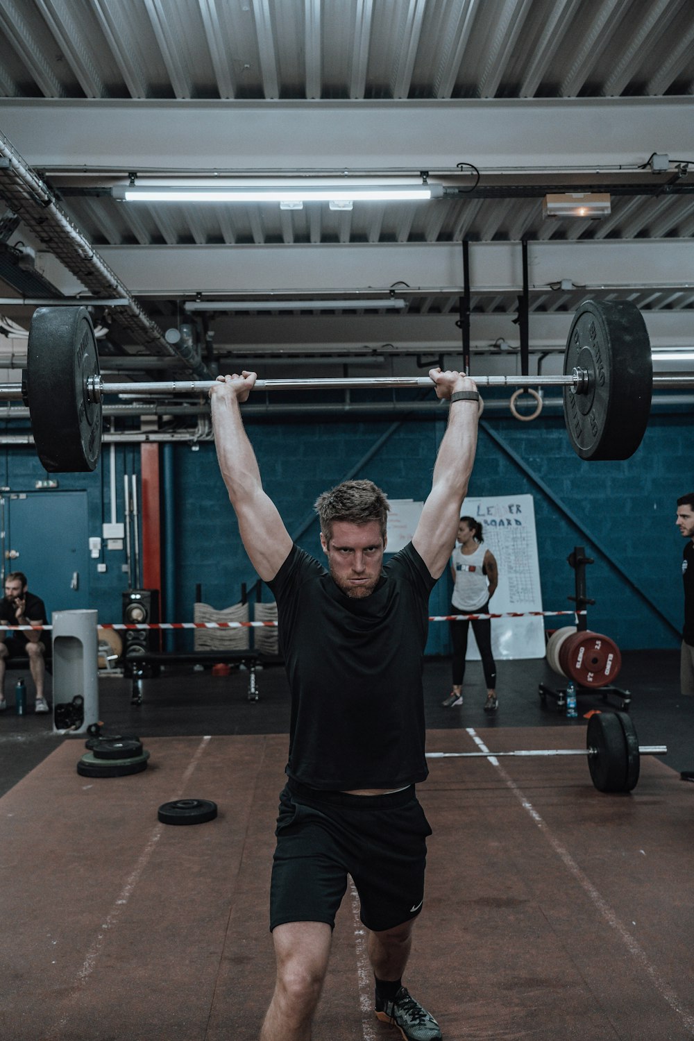 a man lifting a barbell in a gym