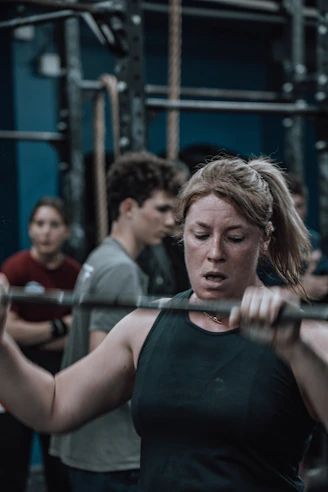a woman lifting a bar in a gym