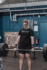 A determined athlete lifting heavy weights in a modern gym setting, showcasing strength and focus.
