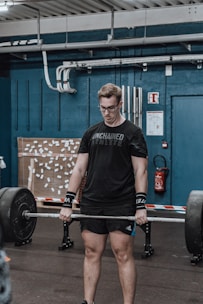 A close-up of a parent lifting weights with determination in a home gym.