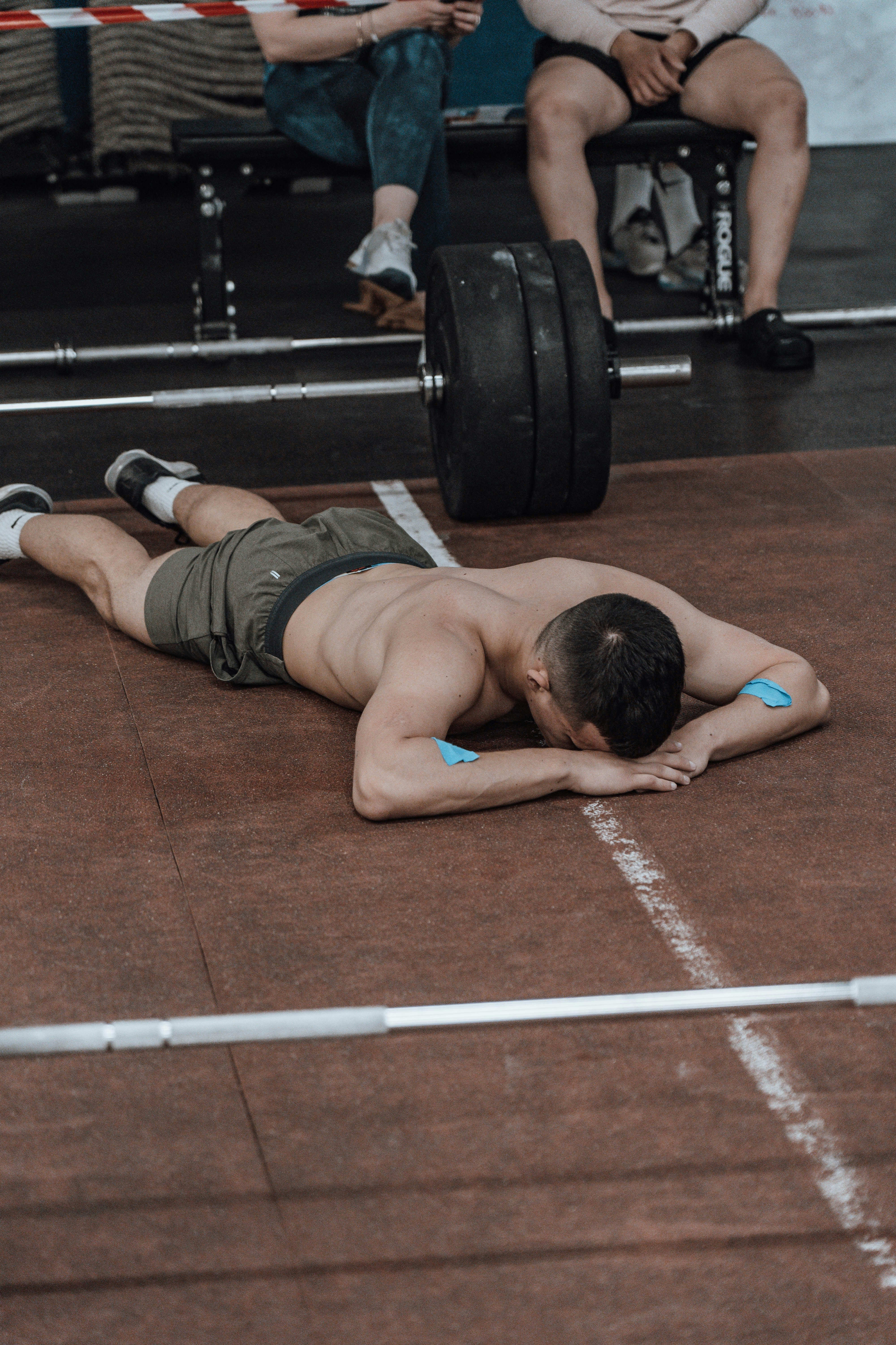 a man laying on the ground while lifting a barbell
