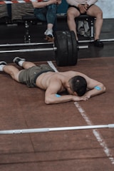 a man laying on the ground while lifting a barbell