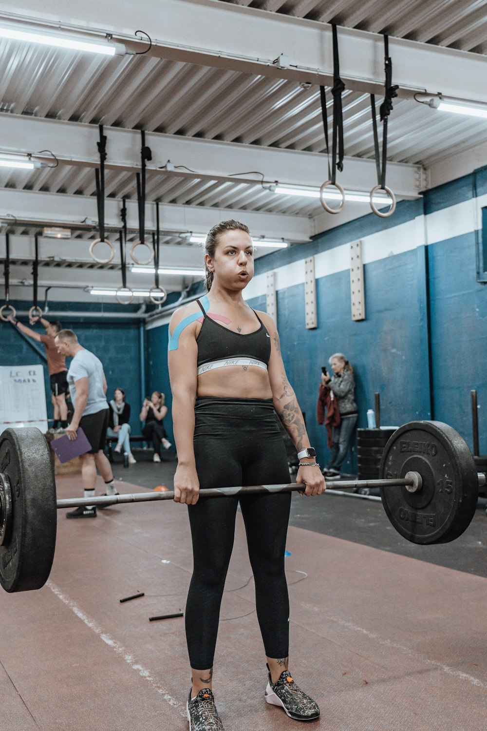 a woman holding a barbell in a gym