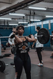 a woman lifting a barbell in a gym