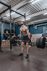 Personal trainer coaching a member on proper form during deadlifts.