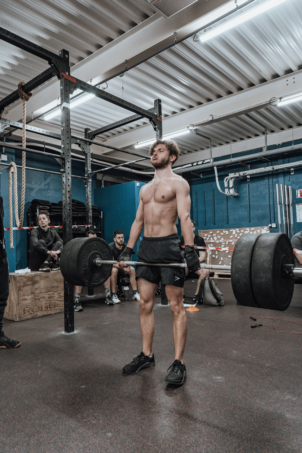 a man with no shirt is holding a barbell