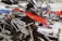 A well-equipped motorcycle workshop featuring a prominently displayed BMW GS motorcycle with red and black colors. The bike is mounted on a lift with various tools and equipment in the background. Another motorcycle can be seen on a lift in the background, highlighting a professional garage setting with organized workspaces.