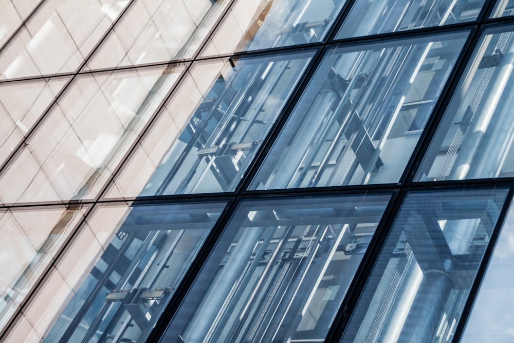 a tall building with lots of windows reflecting the sky