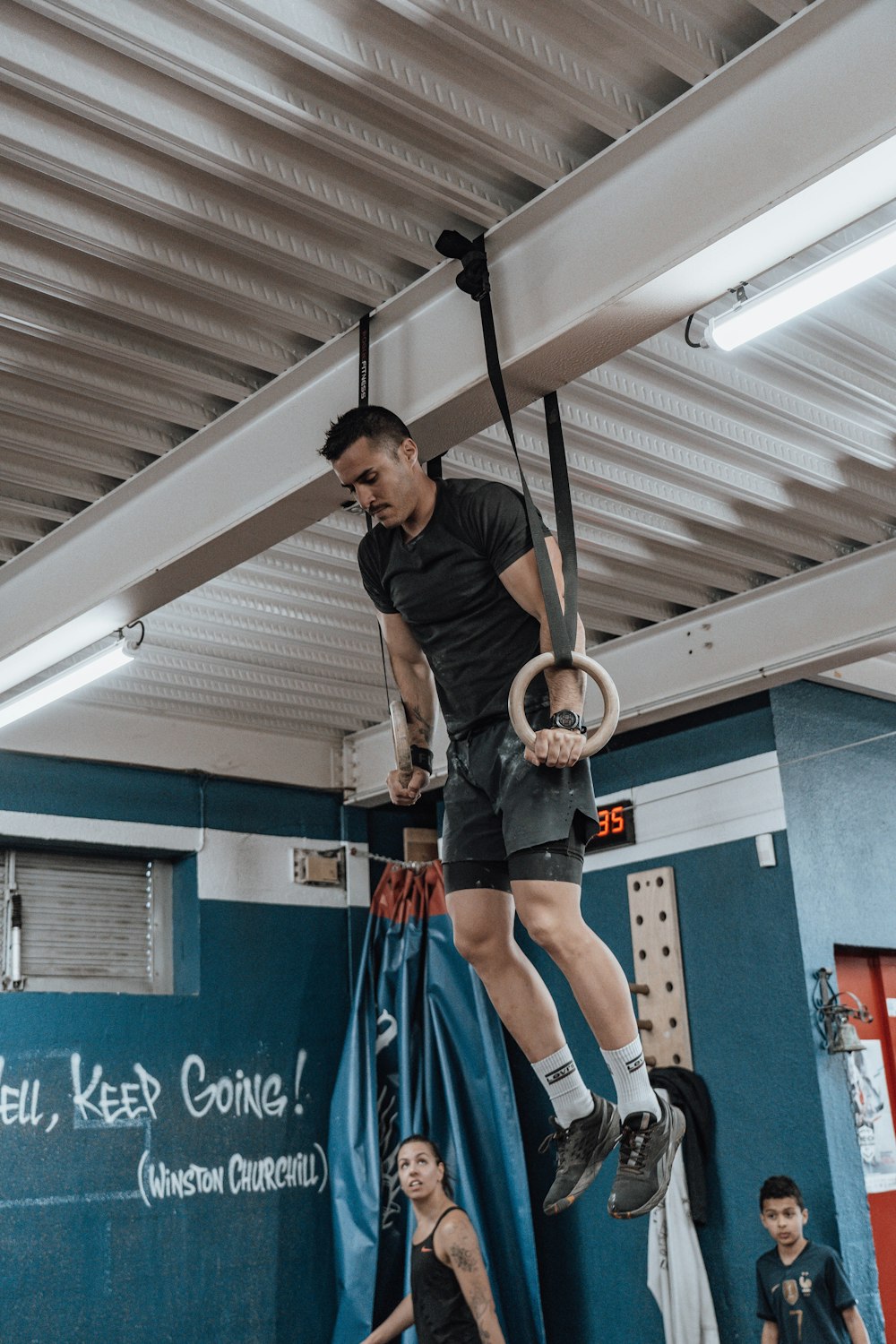 a man is hanging upside down in a gym