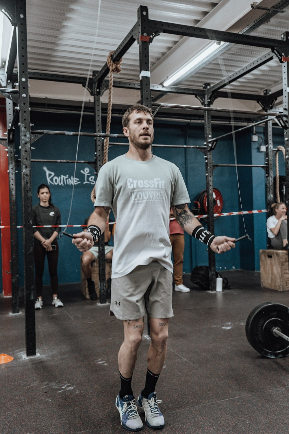 a man standing in a gym holding a barbell
