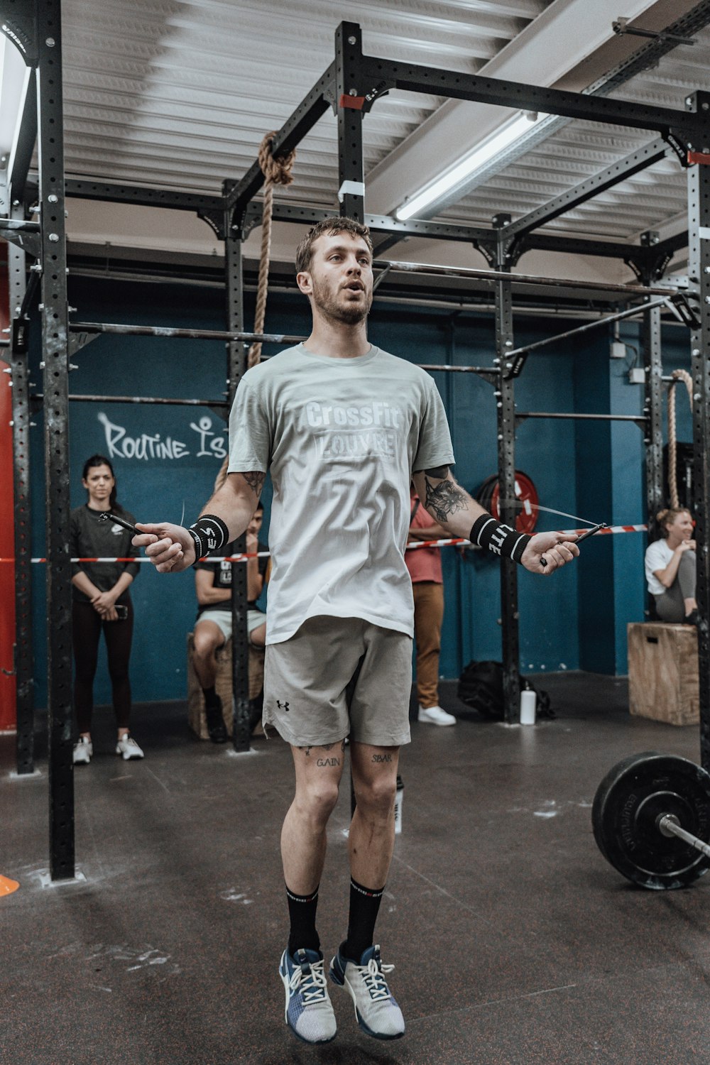 a man standing in a gym holding a barbell