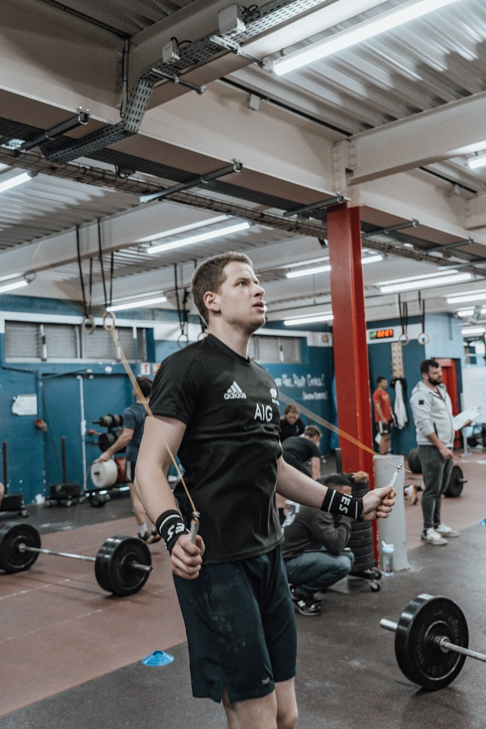 a man standing in a gym holding a barbell