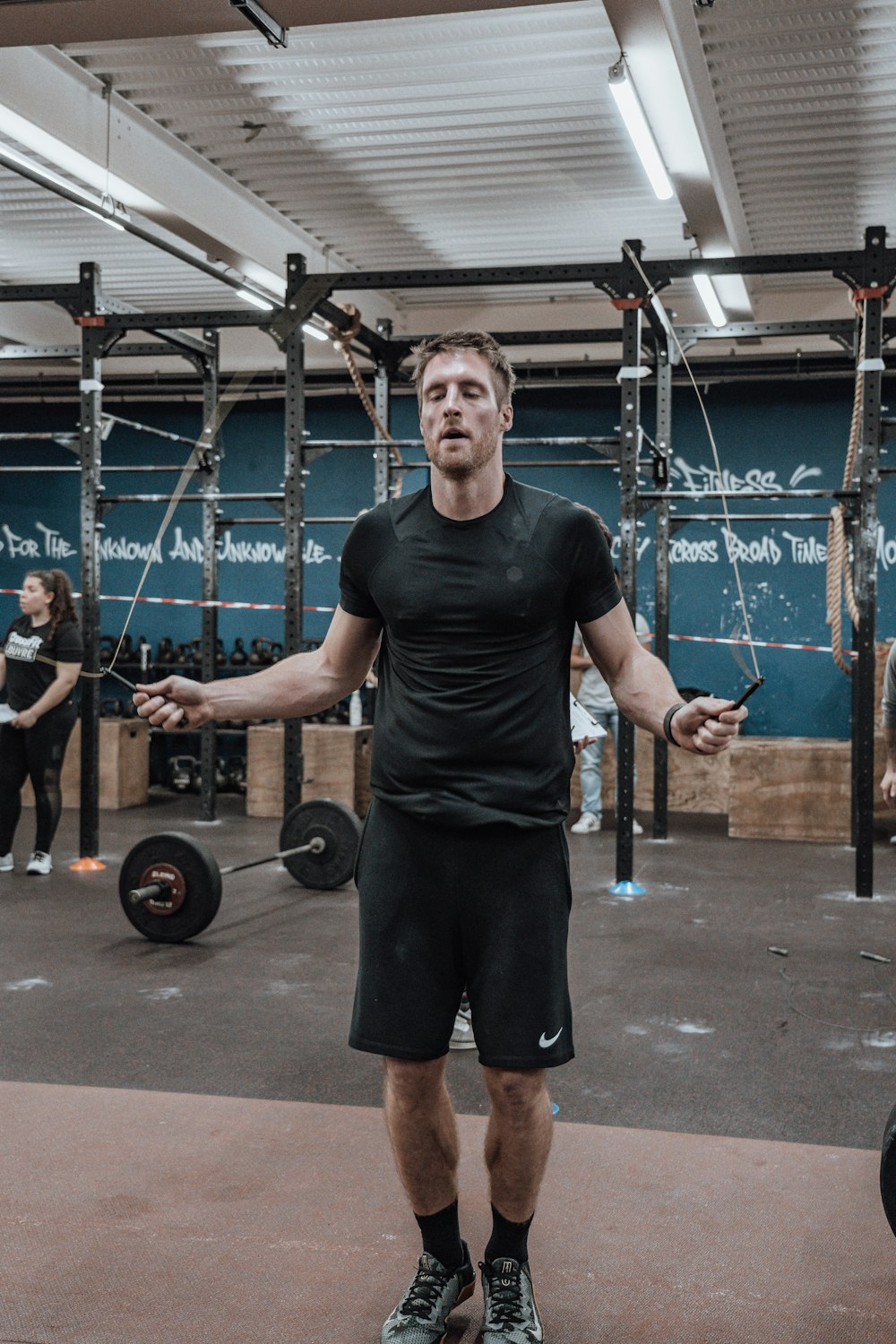 a man standing in a gym holding a barbell