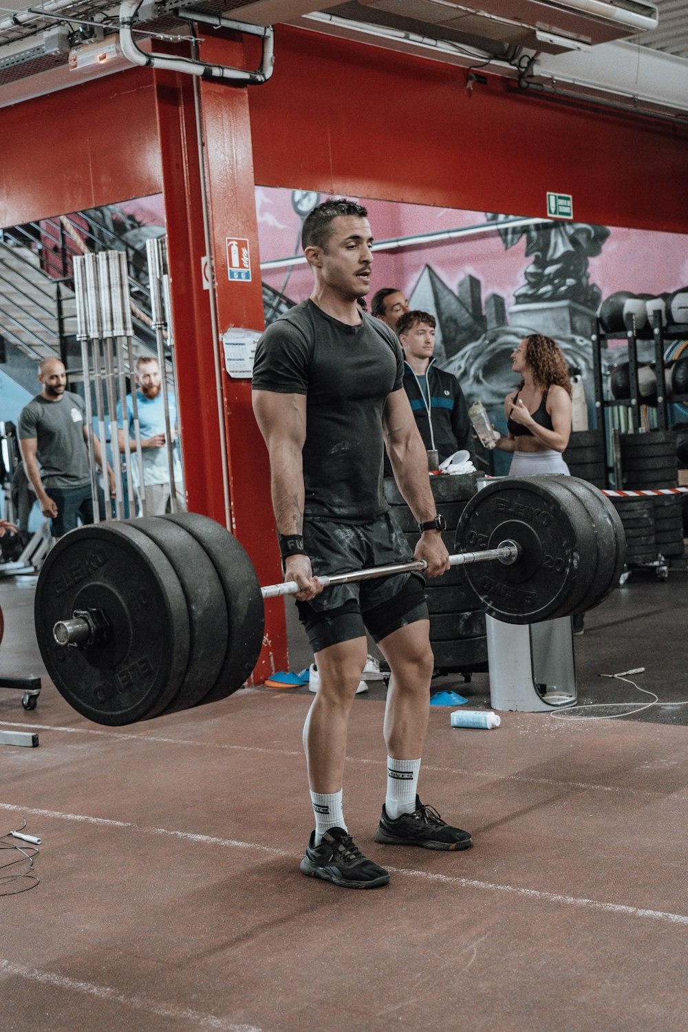 a man holding a barbell in a gym