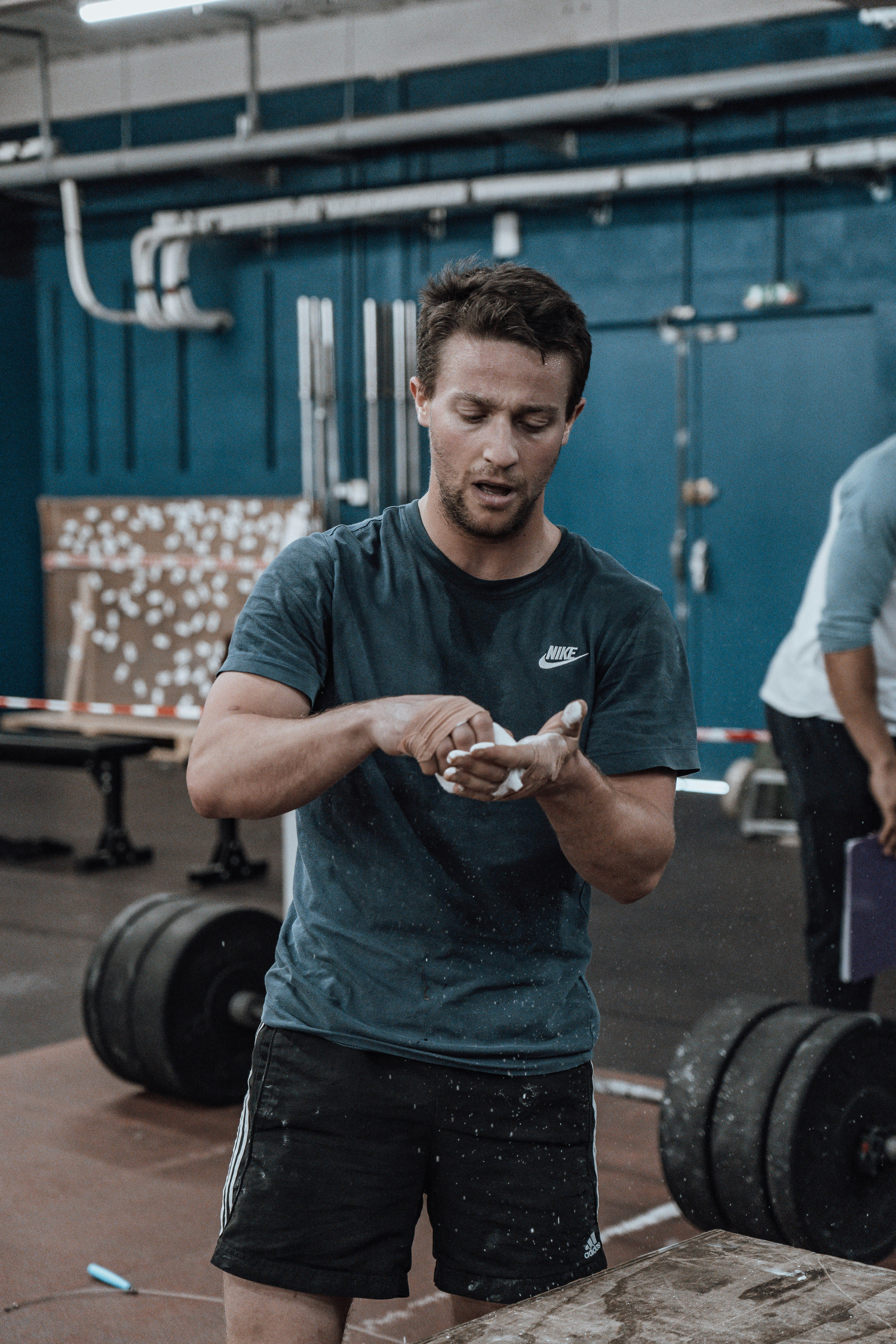 a man standing in a gym holding a cell phone