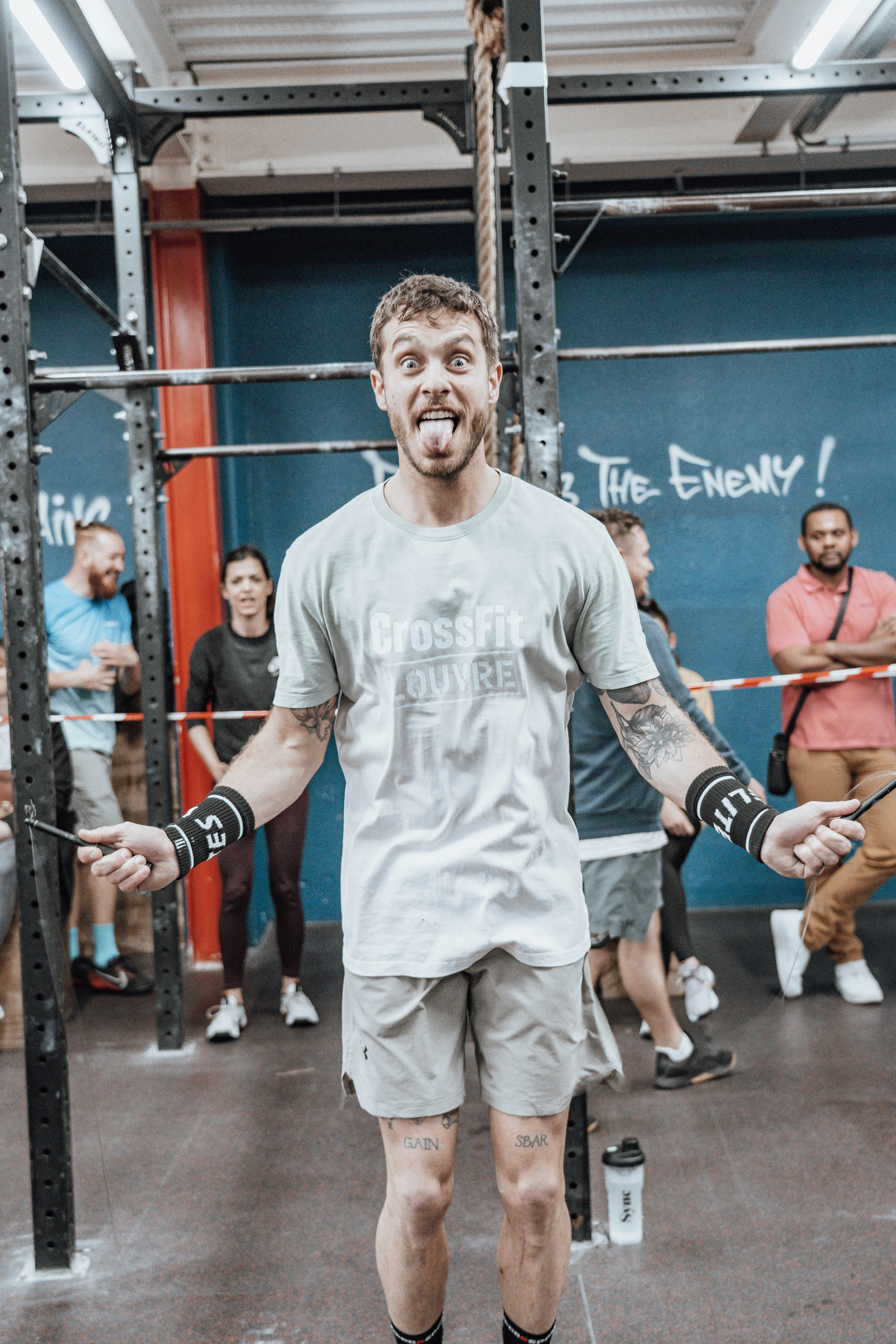 a man standing in a gym holding a bar