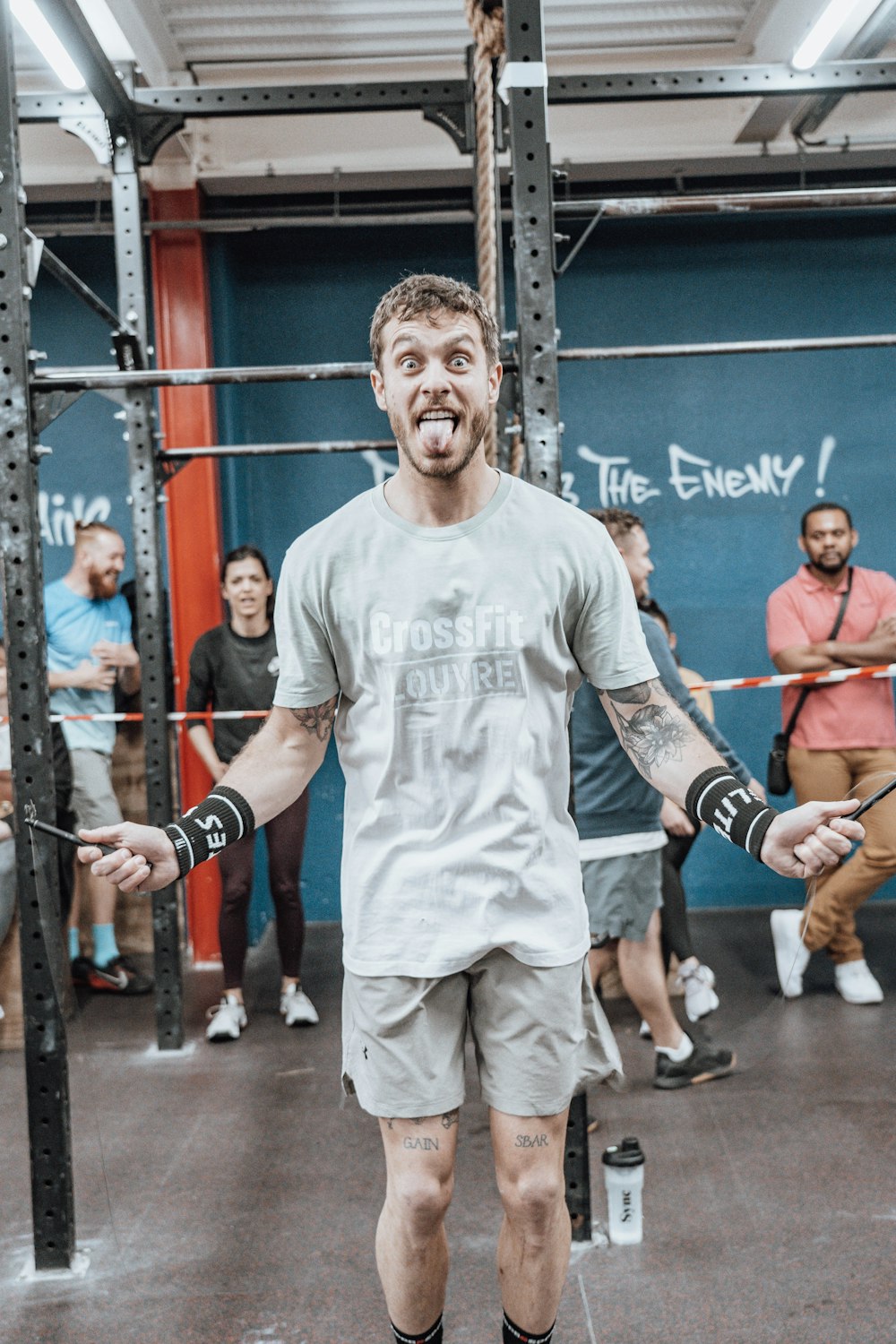 a man standing in a gym holding a bar