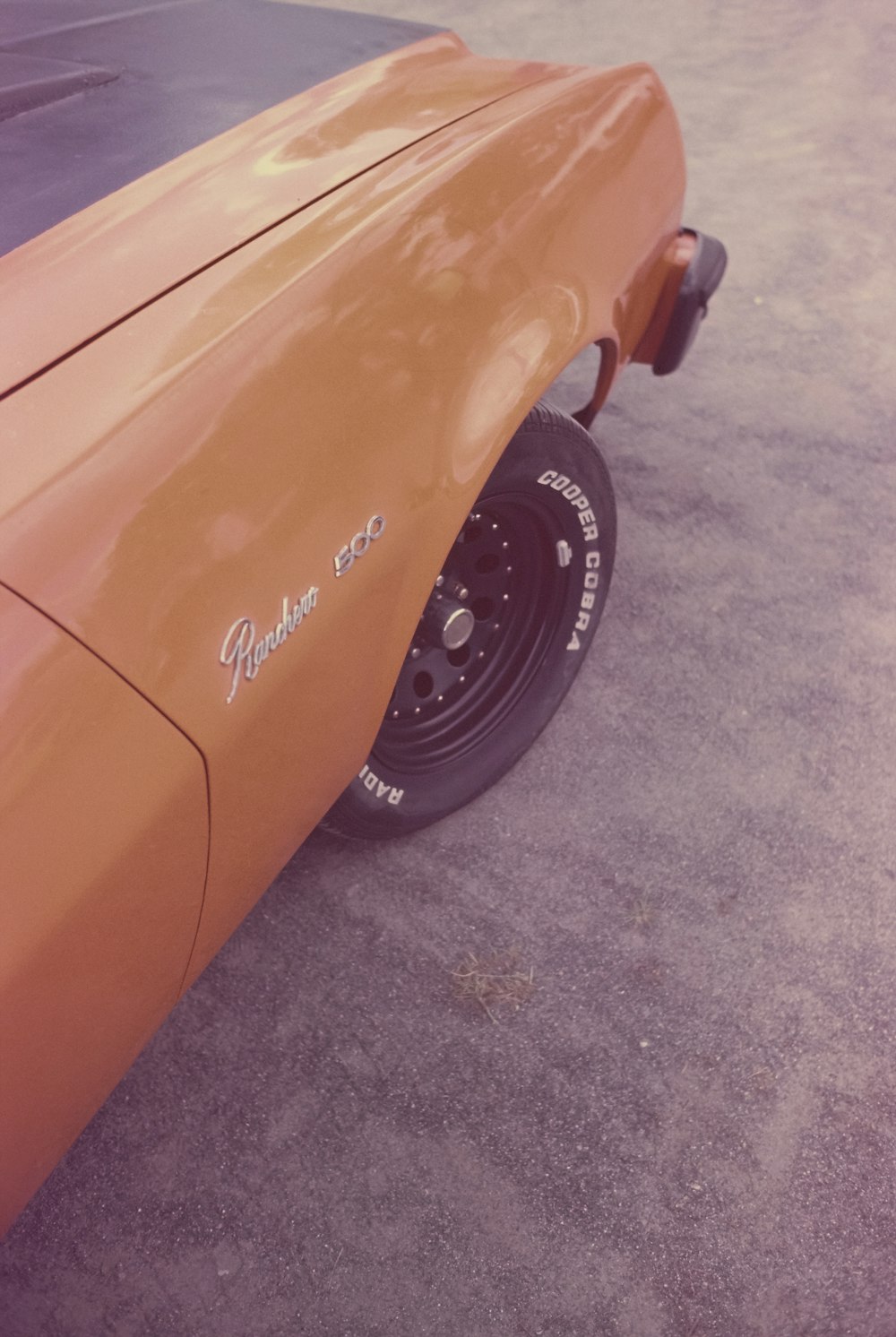 a close up of the side of an orange car