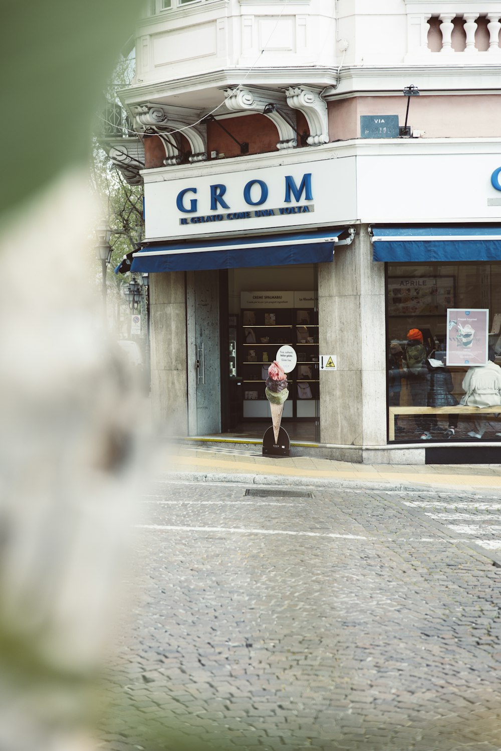 a woman walking down a street in front of a store