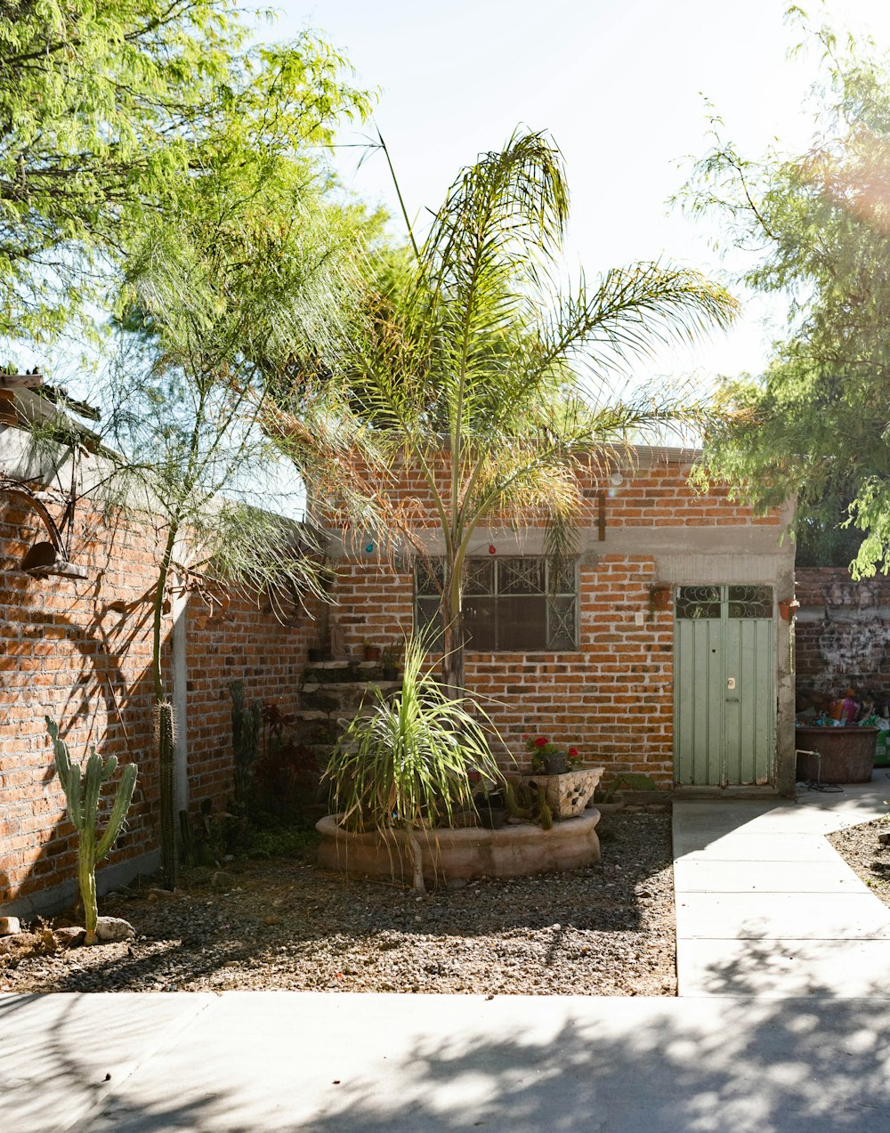 a brick house with a gate and a palm tree