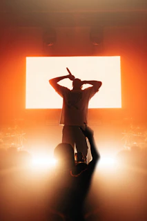 a man standing in front of a large screen