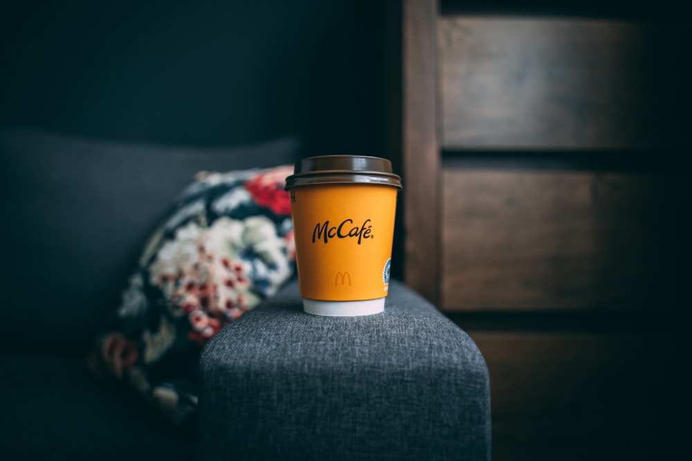 a cup of coffee sitting on top of a chair