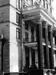 An elegant black and white photo of a historic brick building with character