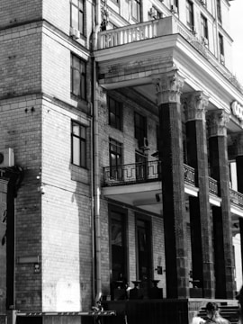 An elegant black and white photo of a historic brick building with character